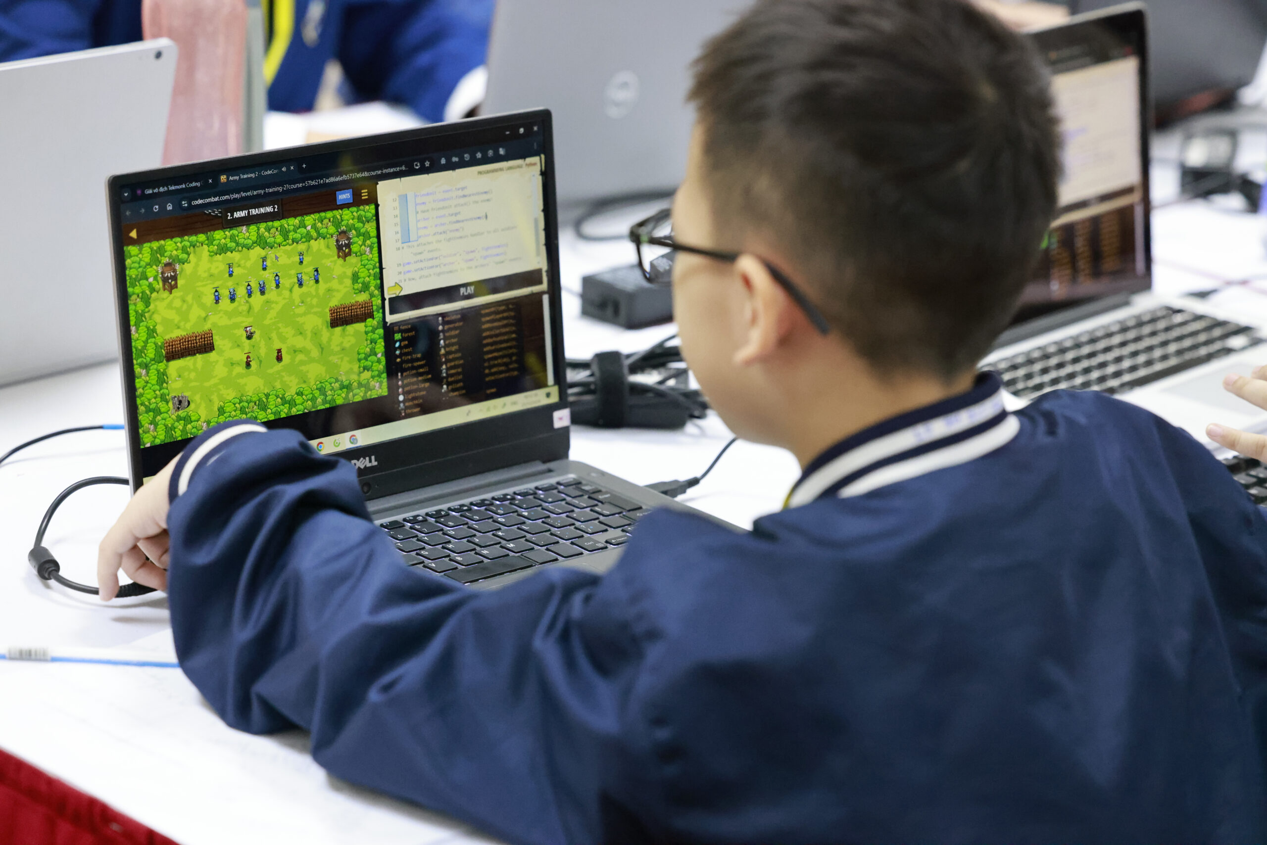 Học sinh viết code và chạy thử một trò chơi trên laptop